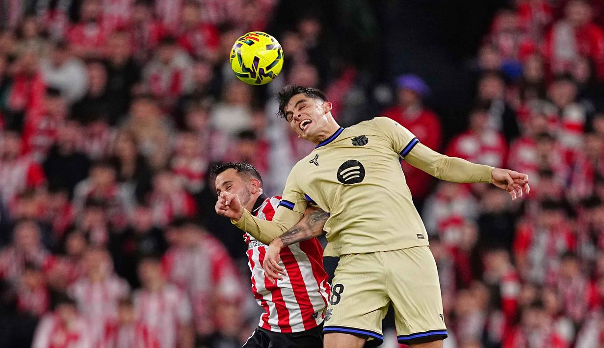 Di babak kedua pertandingan berlangsung sengit. Athletic Bilbao justru mengambil inisiatif serangan dan mereka beberapa kali membuat peluang yang merepotkan barisan pertahanan Barcelona. Tampak dalam foto, pemain Barcelona, Gerard Martin (kanan), berebut bola dengan Alex Berenguer dari Athletic Bilbao berebut bola atas pada pertandingan pekan ke-27 La Liga 2025/2026 di Stadion San Mames, Sabtu 7 Maret 2026 waktu setempat atau Minggu (8/3/2026) dini hari WIB. (AP Photo/Miguel Oses)