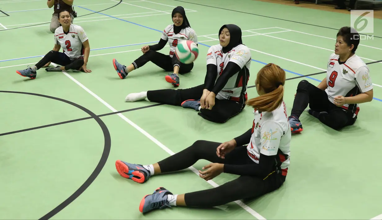 Atlet bola voli duduk putri Asian Para Games Indonesia menahan bola saat latihan di Gelora Bung Karno Arena, Jakarta, Rabu (26/9). Di Asian Para Games 2018, Timnas voli duduk putri Indonesia menargetkan meraih perunggu. (Liputan6.com/Helmi Fithriansyah)