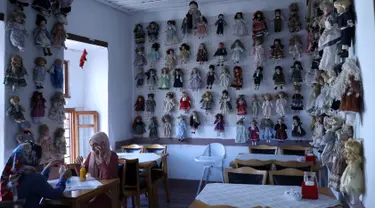 Pengunjung menikmati pesanan dengan boneka yang dipajang di kedai kopi Turki bernama Ankara Castle di Ankara, 8 Agustus 2019. Kedai kopi itu menyambut pengunjung dengan koleksi unik sebanyak 7.500 boneka porselen dari 81 negara yang dikumpulkan pemiliknya selama lebih dari 20 tahun. (Adem ALTAN/AFP)
