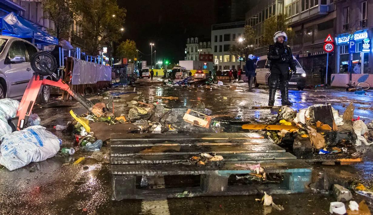 Polisi antihuru-hara berdiri di jalan utama di Brussel, Belgia, 27 November 2022. Polisi harus menutup sebagian pusat Kota Brussel dan bergerak dengan meriam air serta gas air mata untuk membubarkan massa menyusul kerusuhan selama dan setelah Maroko menang 2-0 atas Belgia di Piala Dunia 2022. (AP Photo/Geert Vanden Wijngaert)