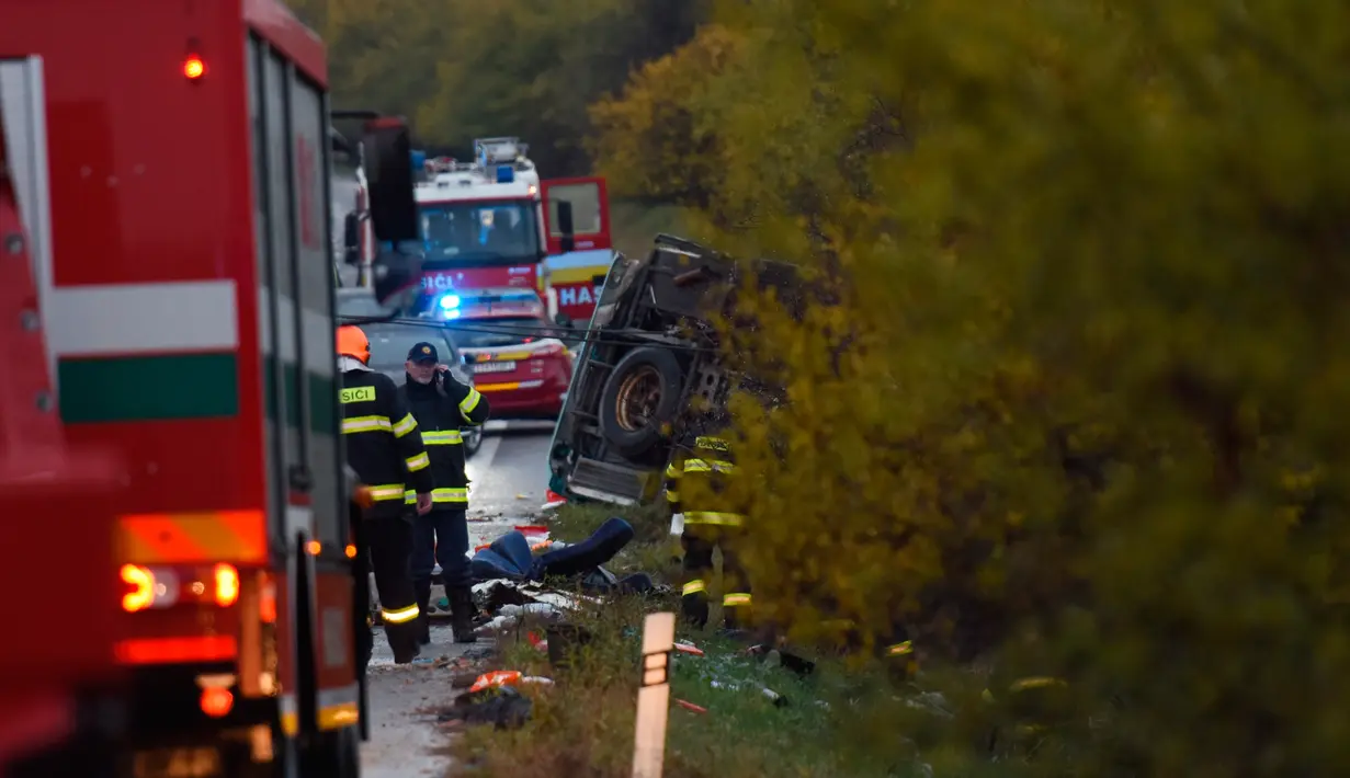 Sebuah bus terbalik (kanan) setelah terlibat kecelakaan dengan truk di Nitranske Hrnciarovce, Slovakia, Rabu (13/11/2019). Empat dari 12 korban tewas dalam kecelakaan bus yang membawa siswa sekolah menengah tersebut adalah anak-anak. (Milan Ivanic/TASR via AP)
