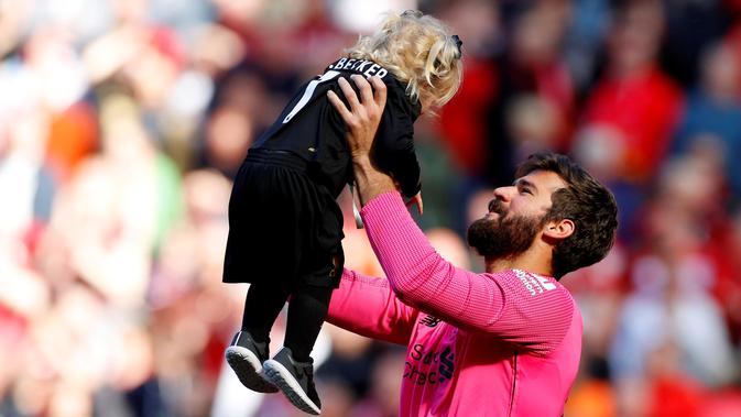 Kiper Liverpool, Alisson Becker, bermain dengan anaknya usai pertandingan melawan Wolverhampton Wanderers pada lanjutan Liga Inggris di Anfield, Inggris (12/5/2019). Liverpool gagal meraih gelar Liga Inggris walaupun berhasil mengalahkan Wolverhampton Wanderers 2-0. (AFP Photo/Phil Noble)