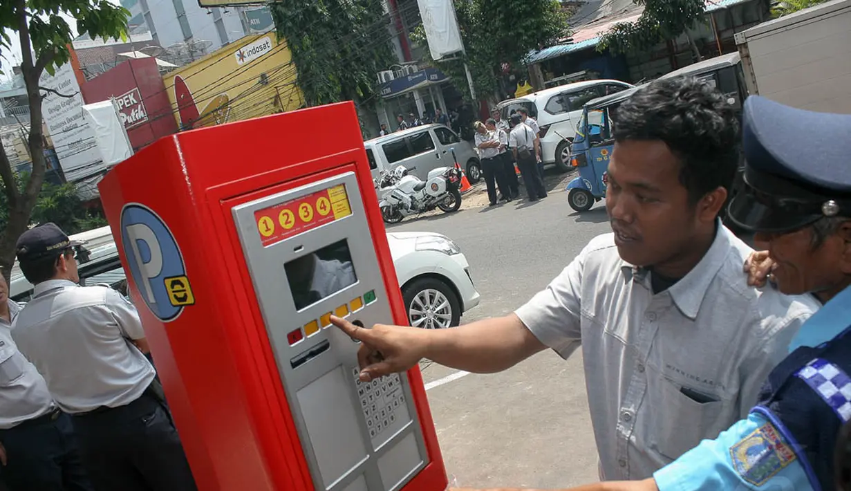 Dibantu petugas, seorang pengguna sudah mulai menerapkan sistem parkir meter ini, Jakarta, (25/9/14). (Liputan6.com/Faizal Fanani) 