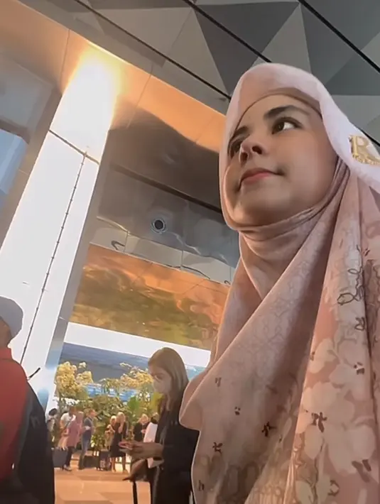 Tampilan Risty Tagor dipadukan dengan kerudung warna senada yang memiliki motif floral ditambah dengan bros keemasan lambang huruf R. [@ristytagor]