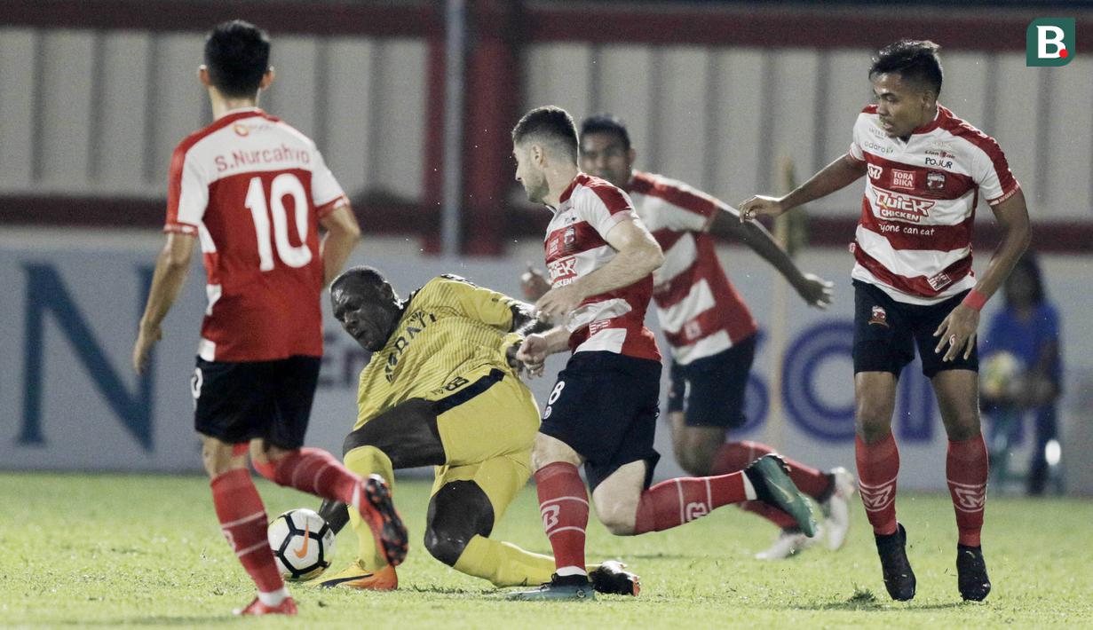 Striker Bhayangkara FC, Herman Dzumafo, berusaha melewati pemain Madura United pada laga Liga 1 di Stadion PTIK, Jakarta, Kamis, (07/6/2018). Bhayangkara FC menang 1-0 atas Madura United. (Bola.com/M Iqbal Ichsan)