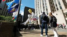 Sejumlah orang melihat balon penari balet karya seniman Jeff Koons, di Rockefeller Center, New York City, AS, Jumat (12/5). Keberadaan balon penari balet menjadi ajang foto pengunjung Rockefeller Center. (Spencer Platt / Getty Images / AFP)