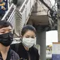 Pekerja mengenakan masker usai menaiki komuter selama kabut asap menyelimuti Bangkok (16/1). Thailand telah berupaya untuk mengatasi polusi yang telah menyelimuti ibukota dalam beberapa pekan terakhir. (AFP Photo/Romeo Gacad)