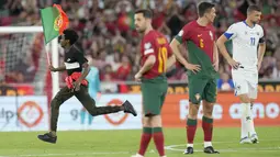 Dia pun berlari dan langsung menghampiri dan memeluk sang kapten Timnas Portugal itu. (AP Photo/Armando Franca)