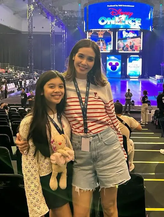 Marsha Timothy yang mengenakan atasan lengan panjang bergaris merah dipadukan celana pendek denim mengajak putrinya Jizzy menyaksikan Disney on Ice. Jizzy mengenakan atasan putih lengan panjang dipadukan celana pendek hitam. [@marshatimothy]