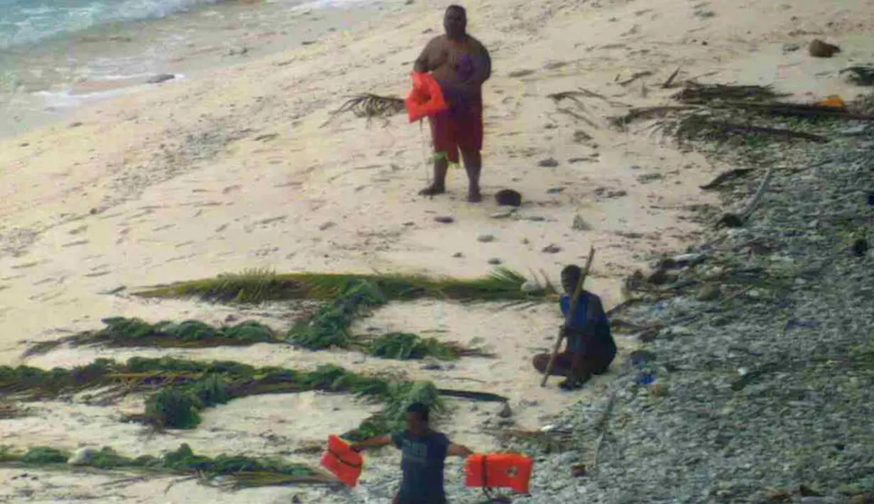 Tiga orang pelaut diselamatkan oleh pasukan AL Amerika Serikat dari pulau tak berpenghuni Faradik, Mikronesia, 7 April 2016. Mereka menuliskan kata "help" menggunakan dahan pohon palem di atas hamparan pasir pantai. (ENSIGN JOHN KNIGHT/NMCO/AFP)