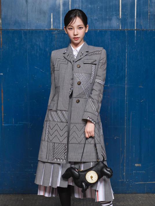 <p>Karina tampil formal dengan mengenakan jaket blazer panjang berwarna dominan abu-abu terang. Sementara rambut hitam panjangnya dibiarkan terikat.</p>