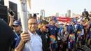Gubernur DKI Jakarta Anies Baswedan membawa obor Asian Games 2018 di Jakarta, Sabtu (18/8). Anies berlari sepanjang 100 meter membawa obor Asian Games 2018. (Liputan6.com/Faizal Fanani)