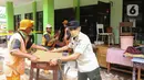 Petugas memindahkan meja dan kursi saat membersihkan ruangan di MTsN 19 Pondok Labu, Jakarta, Jumat (7/10/2022). Petugas PPSU, Satpol PP, dan Dinas Pemadam Kebakaran membersihkan ruang kelas, kantin, dan fasilitas lainnya usai terendam banjir pada Kamis sore kemarin. (Liputan6.com/Herman Zakharia)