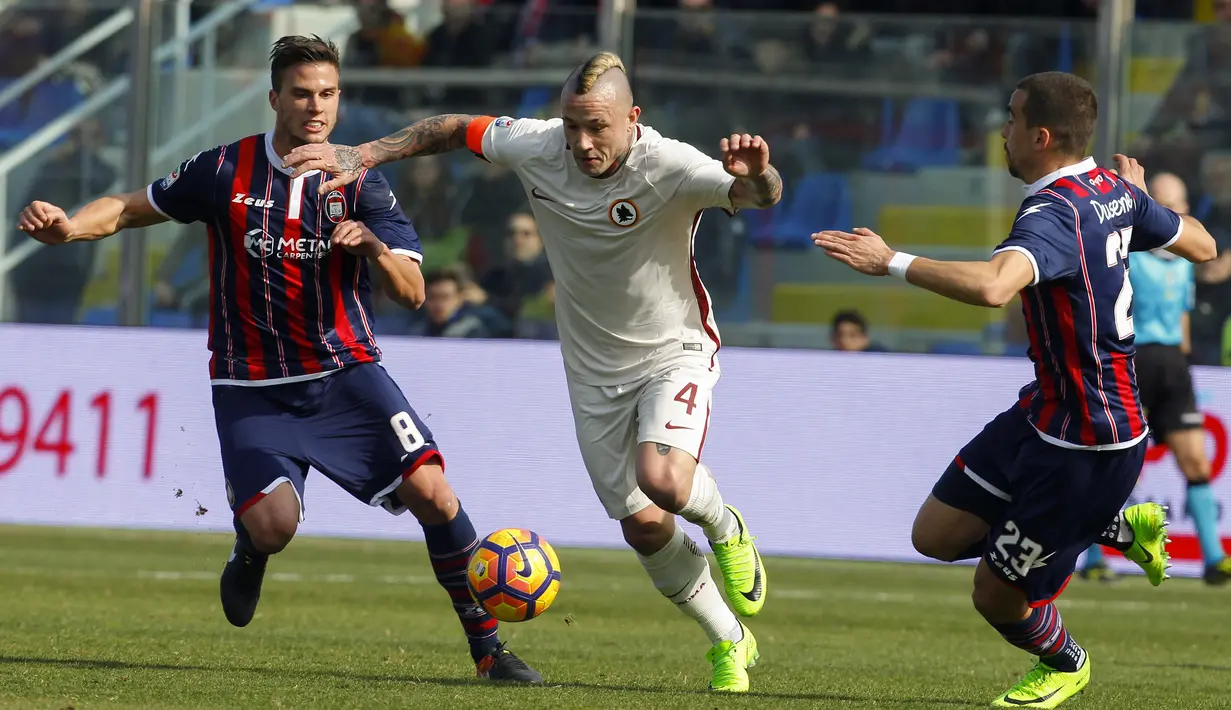 Pemain Roma, Radja Nainggolan (tengah) mencoba melewati hadangan dua pemain  Crotone pada lanjutan Serie A di Ezio Scida stadium, Crotone, Italy (12/2/2017).  AS Roma menang 2-0.  (AFP/Carlo Hermann)