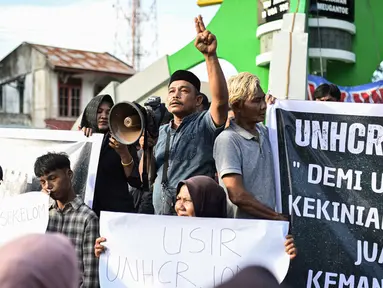 Para pengunjuk rasa memegang poster saat unjuk rasa di Sabang, Provinsi Aceh, Indonesia, Senin (18/12/2023). (AP Photo/Reza Saifullah)