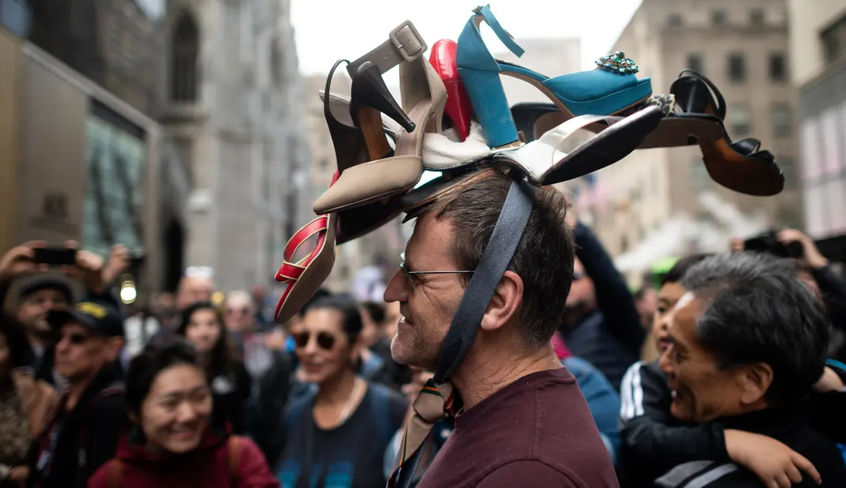 Seorang pria memakai topi yang terbuat dari sepatu wanita dalam Parade Paskah tahunan dan Festival Bonnet di sepanjang Fifth Avenue, New York, AS, Minggu (21/4). Parade Bonnet Easter merupakan parade pada perayaan Paskah di Kota New York yang sudah ada sejak tahun 1870. (Johannes EISELE / AFP)