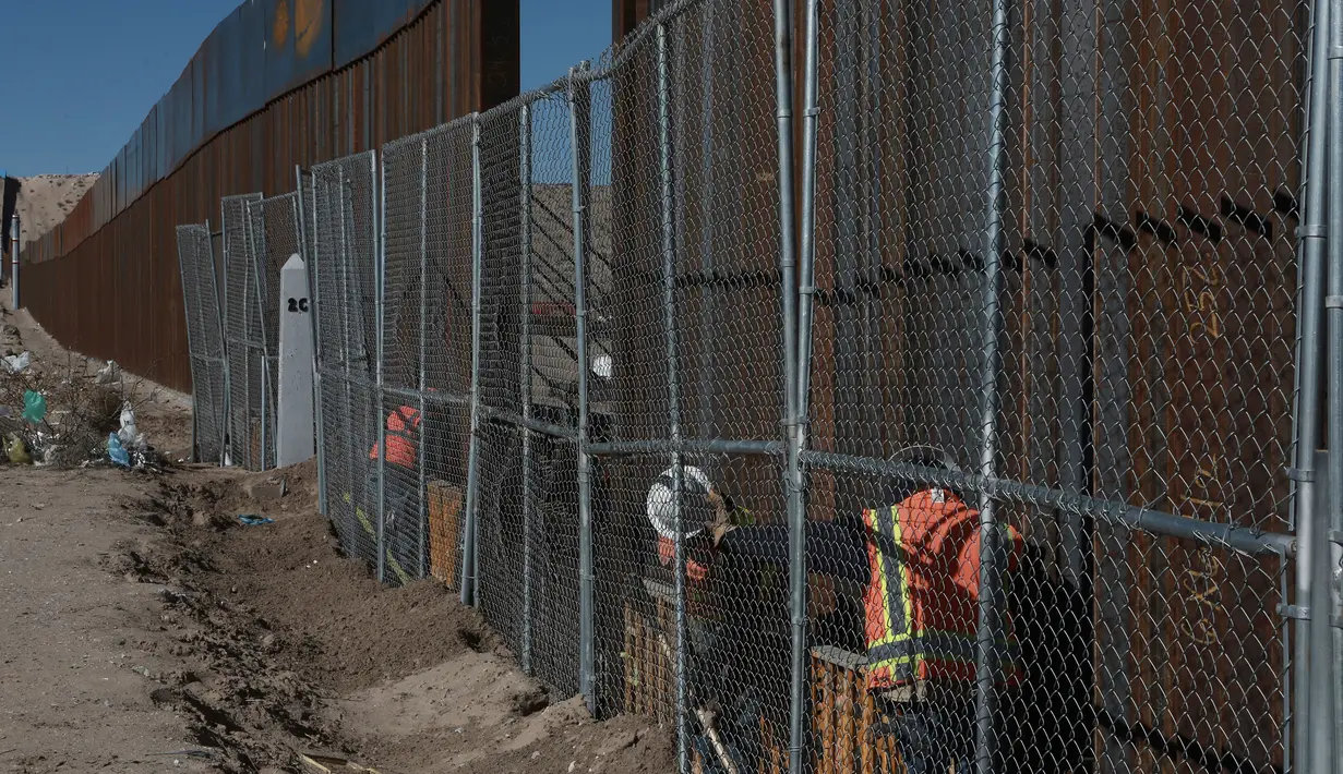 Pekerja menyelesaikan pembangunan tembok yang memisahkan AS dengan Meksiko, Rabu (25/1). Rencananya Trump Wall atau Tembok Trump akan dibangun di perbatasan AS dan Meksiko sepanjang 3.200 kilometer. (AP PHOTO)