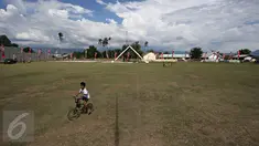 Seorang anak bermain sepeda di Lapangan Sepak Bola Kota Palu, Sigi, Sulteng, Selasa (8/3). Rencananya di lapangan tersebut, Wapres Jusuf Kalla dan istrinya, Mufida Kalla akan menyaksikan fenomena Gerhana Matahari Total. (Liputan6.com/Immanuel Antonius)