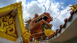 Kepala naga terlihat di atas kuil Buddha Wat Samphran (Kuil Naga) di Nakhon Pathom, sekitar 40 km sebelah barat Bangkok pada 11 September 2020. Kuil Buddha ini menjadi salah satu destinasi wisata di Thailand karena memiliki arsitektur menakjubkan. (Photo by Mladen ANTONOV / AFP)
