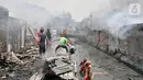 Warga bergotong royong mengambil air dari kali saat berusaha menjinakkan kebakaran di Jalan Kebon Jeruk 13, Taman Sari, Jakarta Barat, Minggu (6/10/2019). Kebakaran diduga akibat anak bermain korek api. (merdeka.com/Iqbal Nugroho)