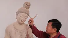 Seniman Du Yongwei mewarnai sebuah patung dengan cat di Dunhuang, Provinsi Gansu, China, Minggu (5/4/2020). Seni patung warna-warni merupakan bentuk kesenian tradisional di Dunhuang. (Xinhua/Du Zheyu)