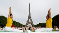 Para peserta ambil bagian dalam acara yoga massal untuk memperingati Hari Yoga Internasional yang jatuh pada 21 Juni di Champs de Mars, depan menara Eiffel, Paris, Prancis, Minggu (17/6). (AFP PHOTO/FRANCOIS GUILLOT)