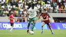 Bek Pape Abou Cisse berebut bola dengan gelandang Mesir Nabil Dounga pada Kualifikasi Piala Dunia 2022 zona Afrika di Stade Me Abdoulaye Wade, Rabu (30/3/2022) dini hari WIB. Senegal dipastikan lolos ke Piala Dunia 2022 setelah menang adu penalti atas Mesir 3-1. (SEYLLOU / AFP)