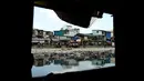 Teresita Gapayao (51) mengais sampah menggunakan rakit yang terbuat dari stereofoam di aliran Sungai Estero de Vitas di Tondo, Manila, Filipina, Kamis (21/4). Teresita menghasilkan sekitar Rp 50ribu/hari dari sampah yang dia kumpulkan. (Noel CELIS/AFP)