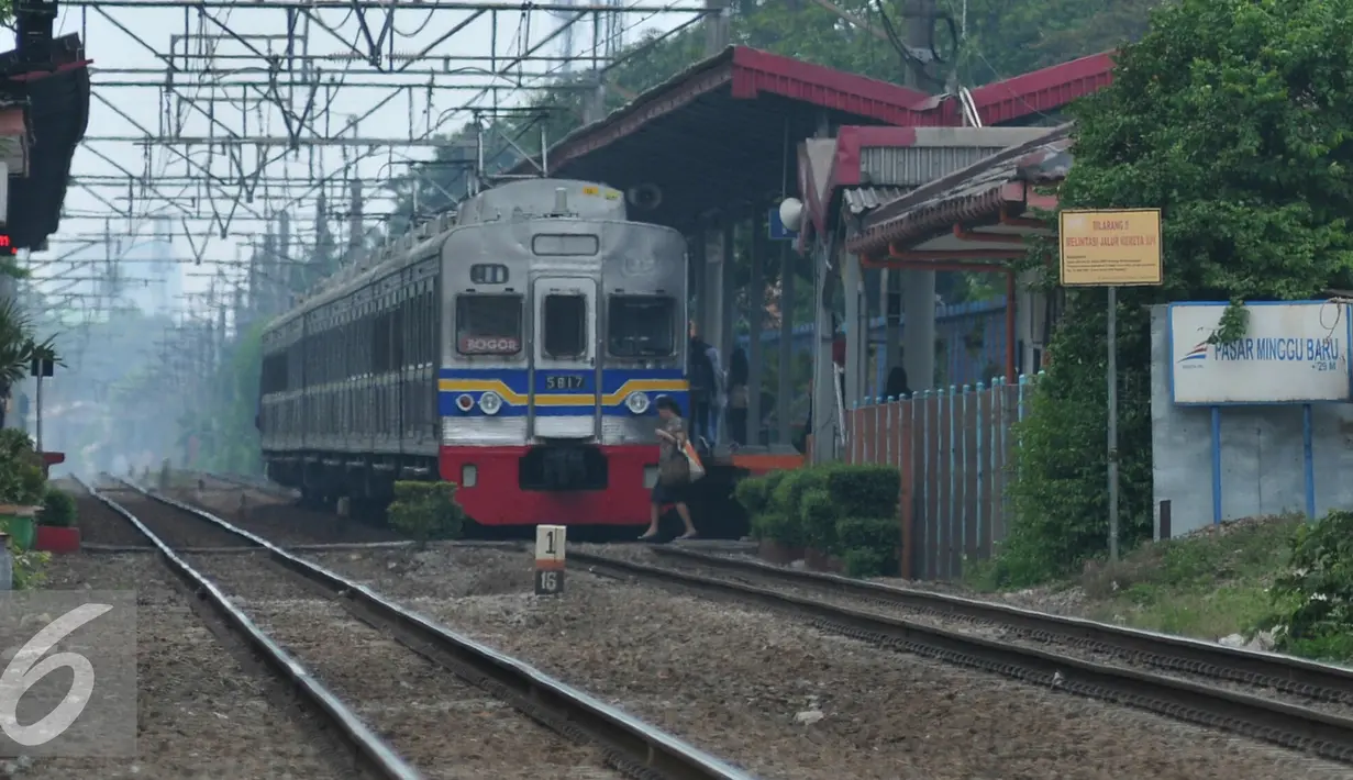 Warga melintasi rel kereta api di perlintasan kereta stasiun Pasar Minggu Baru, Jakarta, Senin (30/11). Untuk mengurangi angka kecelakaan PT KAI membangun JPO di Stasiun Pasar Minggu Baru. (Liputan6.com/Yoppy Renato)