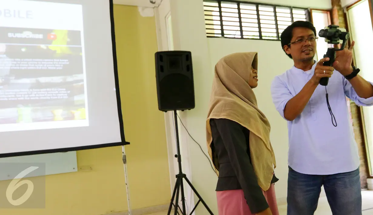 Redaktur Eksekutif Liputan6.com, Andi Muhyiddin memberikan materi Mobile Journalism (Mojo) ke salah satu peserta workshop di Universitas Negeri Semarang (UNNES), Gunung Pati, Semarang, Rabu (5/4). (Liputan6.com/Yoppy Renato)