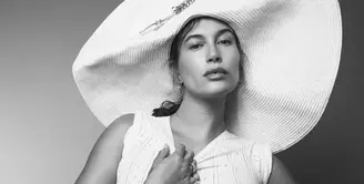 Dalam sebuah foto hitam-putih, terlihat Hailey Bieber dengan baby bumpnya yang semakin membesar mengenakan setelan atasan tanpa lengan dan celana pendeknya, dipadu topi super lebar. [Foto: Instagram/jdblegend_]