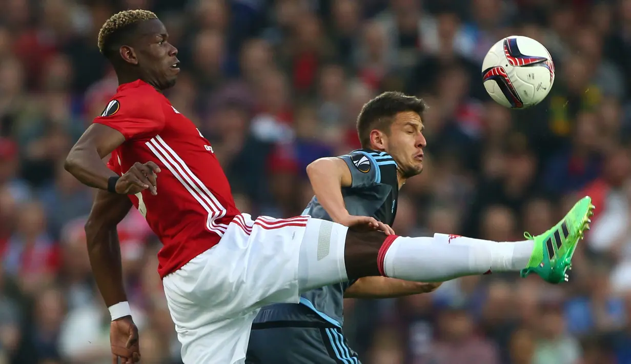 Gelandang MU, Paul Pogba berebut bola dengan gelandang Celta Vigo, Nemanja Radoja saat bertanding pada leg kedua Liga Europa di stadion Old Trafford, Inggris,(11/5). MU melaju ke final usai menang dengan aggregat 2-1. (AP Photo/Dave Thompson)