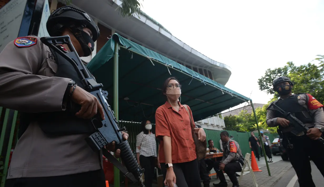Polisi bersenjata berjaga di depan halaman Gereja Kristus Raja, Jakarta Jumat (2/4/2021). Penjagaan ini untuk pengamanan umat kristiani yang sedang melakukan ibadah Jumat Agung pada perayaan Paskah. (merdeka.com/Imam Buhori)