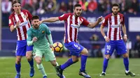 Bintang Barcelona, Lionel Messi, berebut bola dengan pemain Atletico Madrid. Pada laga ini Barcelona turun memakai formasi 3-3-1-3, sementara Atletico menggunakan skema 4-4-2. (AFP/Gerard Julien)