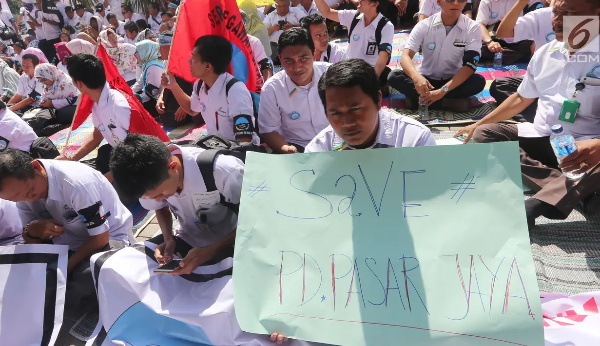 Serikat Pekerja (SP) PD Pasar Jaya membawa poster saat menggelar unjuk rasa di depan Kantor PD Pasar Jaya, Jakarta, Rabu (2/8). Mereka memprotes pengangkatan tenaga profesional yang dianggap merugikan karyawan lama. (Liputan6.com/Angga Yuniar)