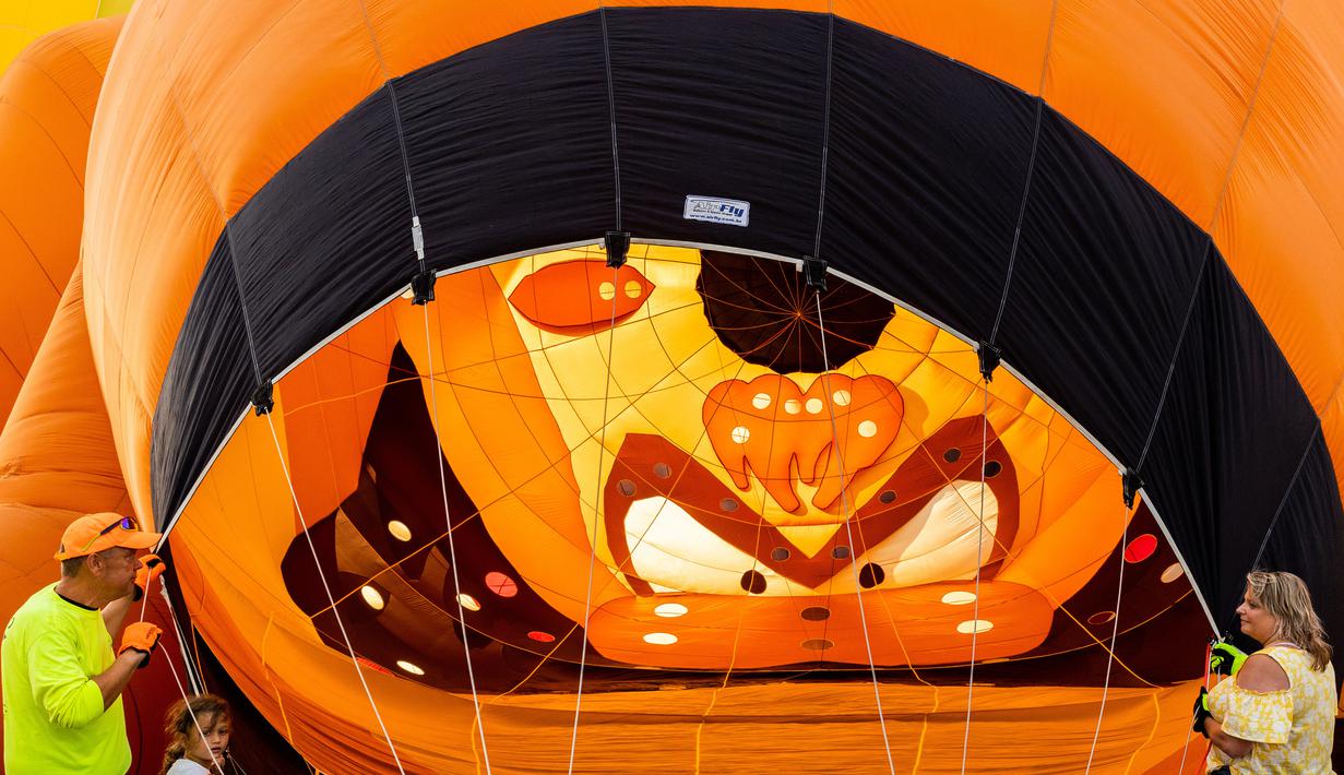 Seorang kru darat membantu mengembangkan balon udara pada New Jersey Lottery Festival of Ballooning di Bandara Solberg, Readington, New Jersey, Amerika Serikat, 29 Juli 2022. Festival yang berlangsung hingga 31 Juli ini akan menampilkan sebanyak 100 balon. (AP Photo/Julia Nikhinson)