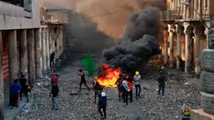 Demonstran antipemerintah membakar barang-barang saat pasukan keamanan menutup Rasheed Street selama bentrok di Baghdad, Irak, Kamis (28/11/2019). Sebanyak 27 demonstran antipemerintah tewas ditembak mati oleh pasukan keamanan Irak dalam sehari. (AP Photo/Khalid Mohammed)