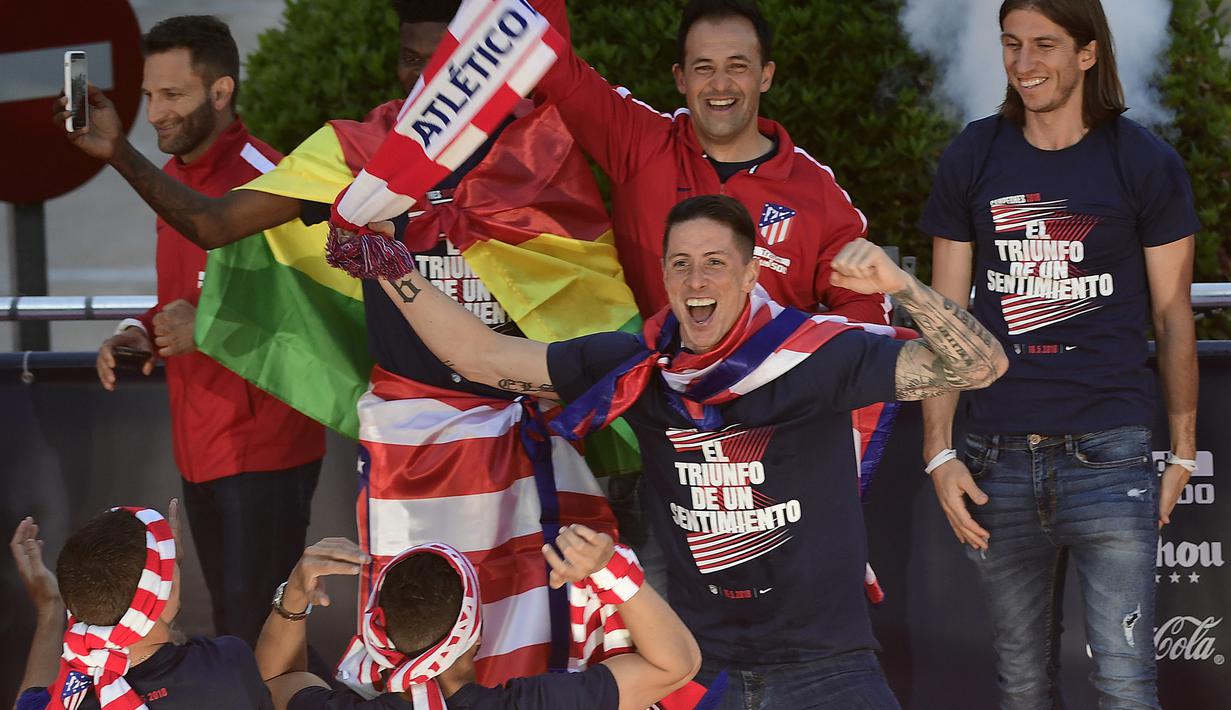 Striker Atletico Madrid, Fernando Torres, bernyanyi saat mengikuti konvoi perayaan gelar Liga Europa di Madrid, Jumat (18/5/2018). Kota Madrid menjadi merah saat perayaan gelar juara Atletico. (AFP/Javier Soriano)