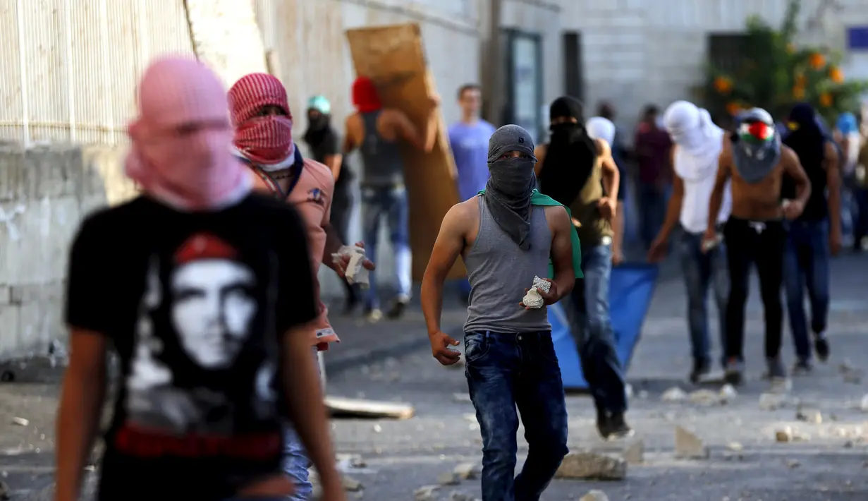 Warga Palestina ikut ambil bagian dalam bentrokan dengan polisi Israel di Shuafat, sebuah daerah pinggiran Arab, Yerusalem, Senin (5/10/2015). Seorang remaja Palestina tewas pada Senin dalam bentrokan di Tepi Barat. (REUTERS/Ammar Awad)