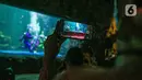 Pengunjung menyaksikan pertunjukan drama teatrikal bertajuk Rabbit Underwater Show In Mission Save The Ocean di Sea World Ancol Jakarta, Selasa (30/3/2021). Pertunjukan digelar untuk mengedukasi warga dalam menjaga ekosistem laut dari sampah atau polusi laut. (Liputan6.com/Faizal Fanani)
