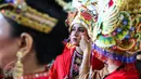 Seorang penari sedang memperbaiki mahkota di balik panggung Pentas Budaya di Terminal 3 Bandara Seokarno Hatta, Tangerang, Banten Senin (15/08). (Liputan6.com/Fery Pradolo)