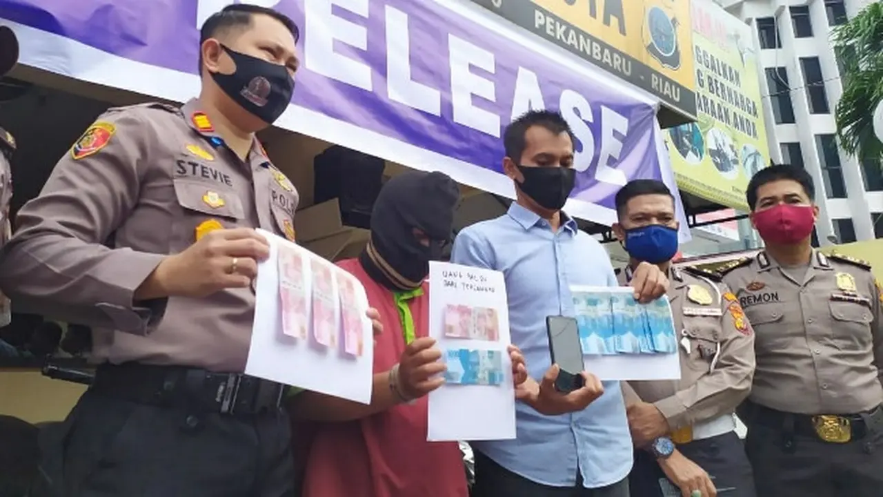Tersangka pengedar uang palsu di Polsek Pekanbaru Kota bersama barang bukti kejahatannya.