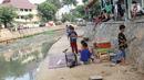 Suasana di bantaran anak Sungai Ciliwung, Jakarta, Rabu (6/6). Meskipun tidak layak sebagai tempat bermain, namun lokasi itu menjadi tempat bagi anak-anak di kawasan tersebut untuk menunggu waktu berbuka. (Liputan6.com/Immanuel Antonius)