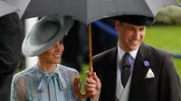 Duchess of Cambridge Kate Middleton bersama suaminya Duke of Cambridge Pangeran William mengenakan payung saat menghadiri ajang pacuan kuda Royal Ascot di Ascot, Inggris, Selasa (18/6/2019). (ADRIAN DENNIS/AFP)
