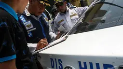 Seorang pengendara terlihat pasrah saat petugas memergoki mobilnya parkir sembarangan di Jalan Pramuka, Jakarta, Kamis (18/9/2014) (Liputan6.com/Faizal Fanani)