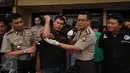 Kapolres Jakarta Barat, Kombes (Pol) Rudy Heriyanto AN (kedua kanan) menunjukkan luka tembak yang dialami timnya saat melakukan penangkapan tersangka pengedar narkotika jenis sabu di Jakarta, Rabu (23/3/2016). (Liputan6.com/Helmi Fithriansyah)