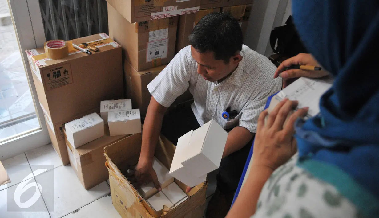 Petugas memeriksa kemasan kardus telepon seluler ilegal di gudang distributor, di ruko kawasan Cempaka Mas, Jakarta, Senin(15/6/2015). Penggeledahan tersebut terkait beberapa laporan dari masyarakat. (Liputan6.com/Herman Zakharia)