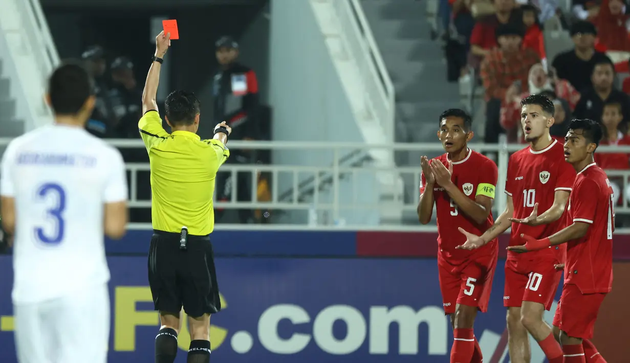 Wasit asal China, Shen Yinhao memberikan kartu merah kepada pemain belakang Indonesia Rizky Ridho saat pertandingan semifinal Piala Asia U-23 Qatar 2024 antara Indonesia melawan Uzbekistan di Stadion Abdullah Bin Khalifa, Doha, 29 April 2024. (KARIM JAAFAR/AFP)