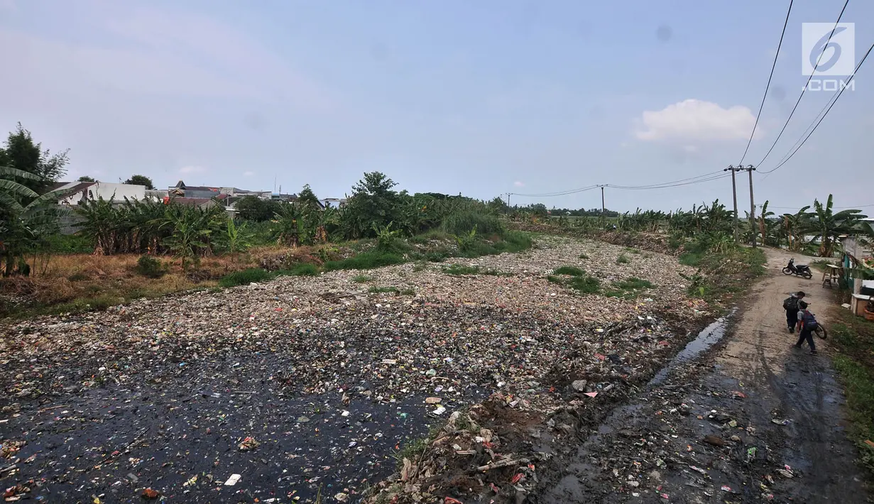 Warga beraktivitas di pinggir Kali Pisang Batu yang dipenuhi sampah, Tarumajaya, Bekasi, Rabu (9/1). Tumpukan sampah tersebut berasal dari limbah rumah tangga. (Merdeka.com/Iqbal S Nugroho)