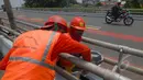 Sejumlah petugas Suku Dinas Pekerjaan Umum  melakukan peremajaan dengan melakukan pengecatan besi pembatas Fly Over di kawasan Cakung, Jakarta,  Rabu (1/4/2015). Panjang pembatas mencapai 120 meter (Liputan6.com/Yoppy Renato)